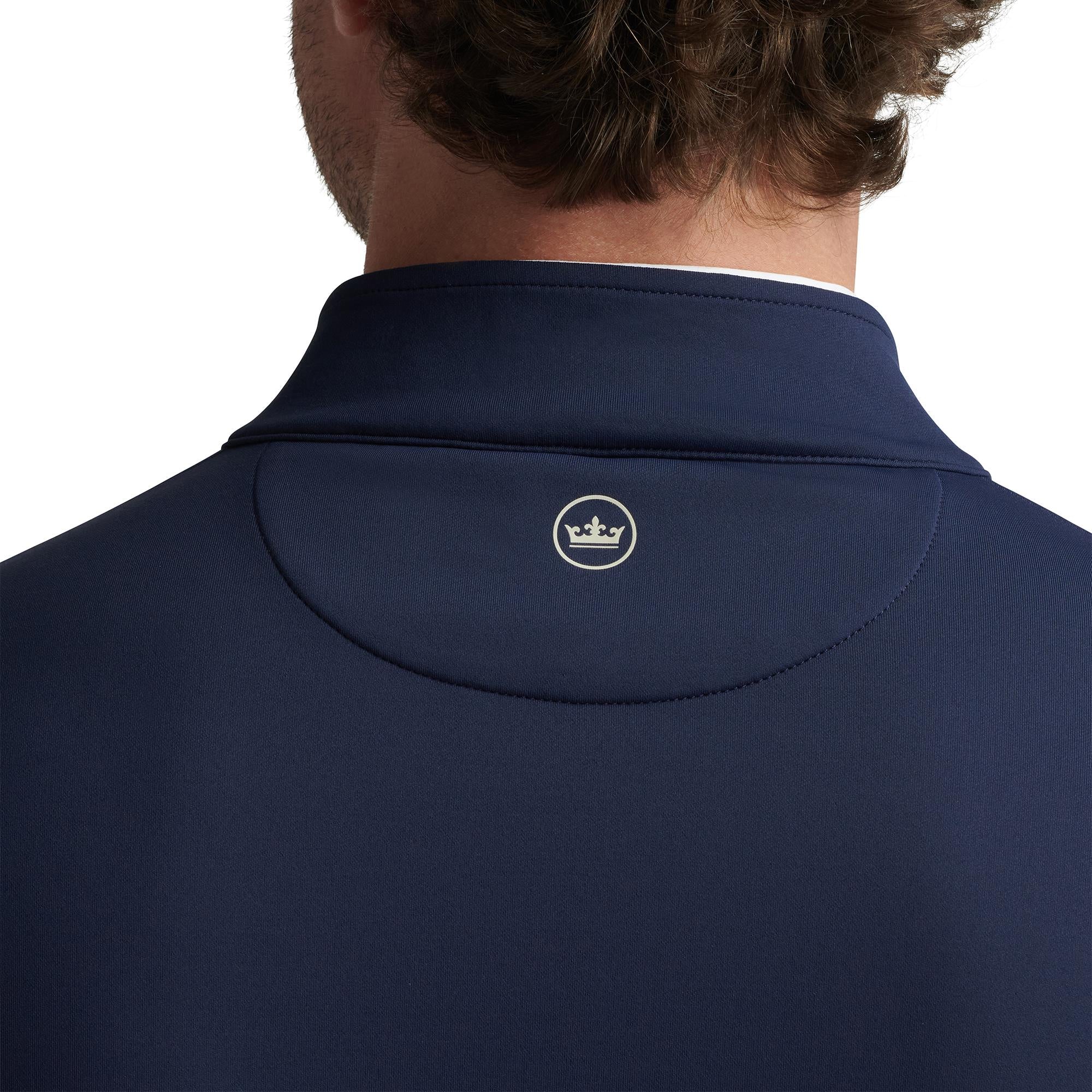 Close-up of Peter Millar logo on back collar – premium men's golf apparel and midlayer top