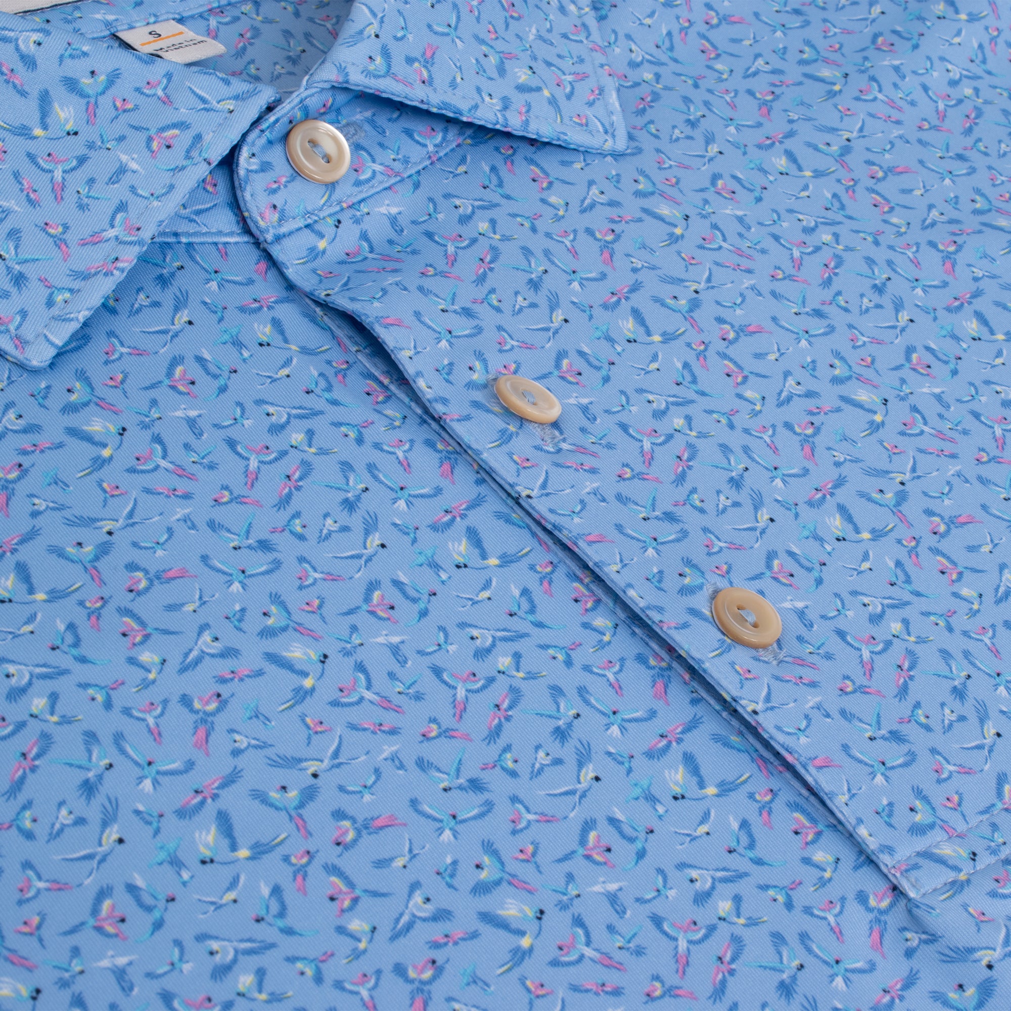  Close-up showing fabric pattern and button placket of Peter Millar Macaw Country Polo Shirt – performance golf polo