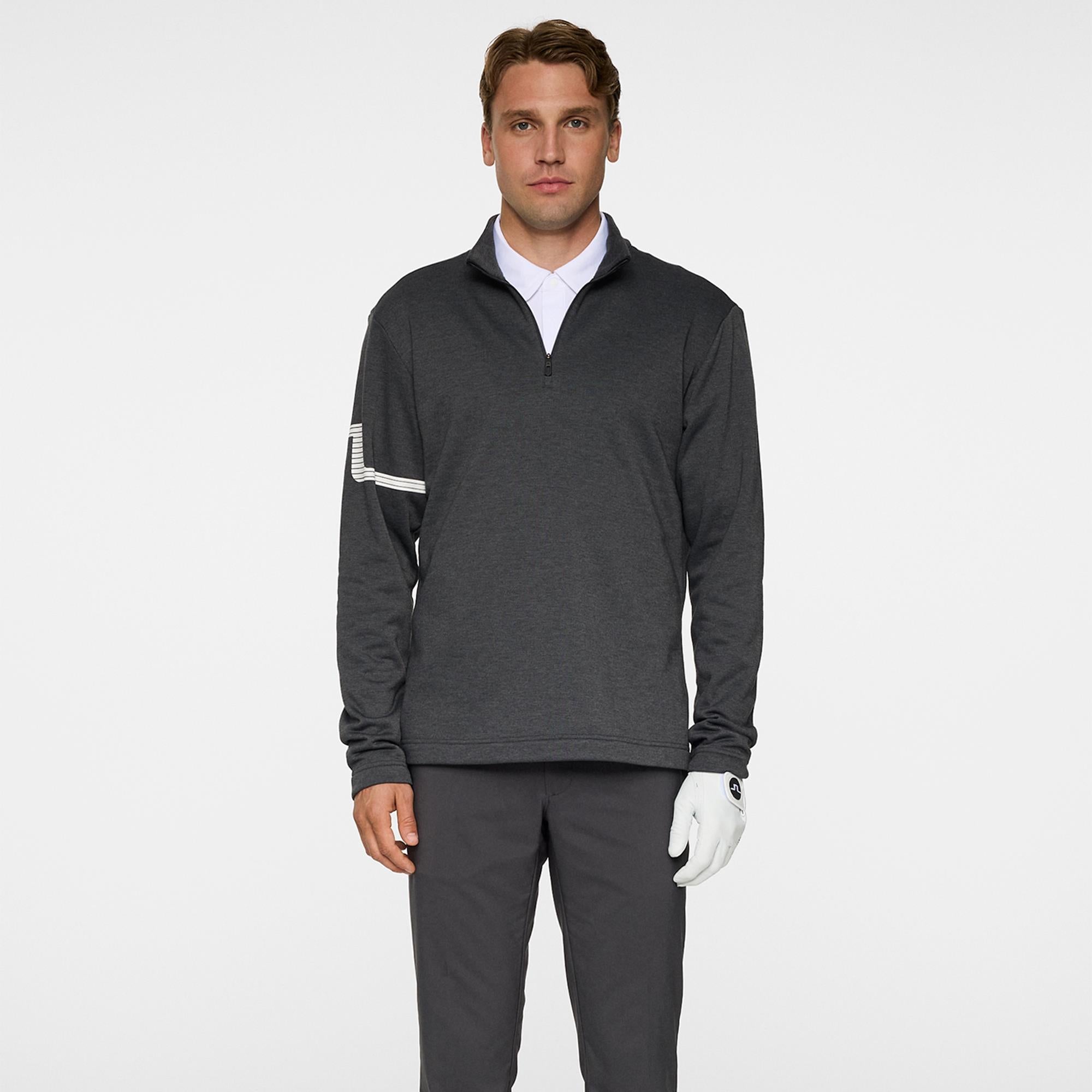 Model holding golf club wearing J.Lindeberg Heath Strike Mid Layer in Asphalt