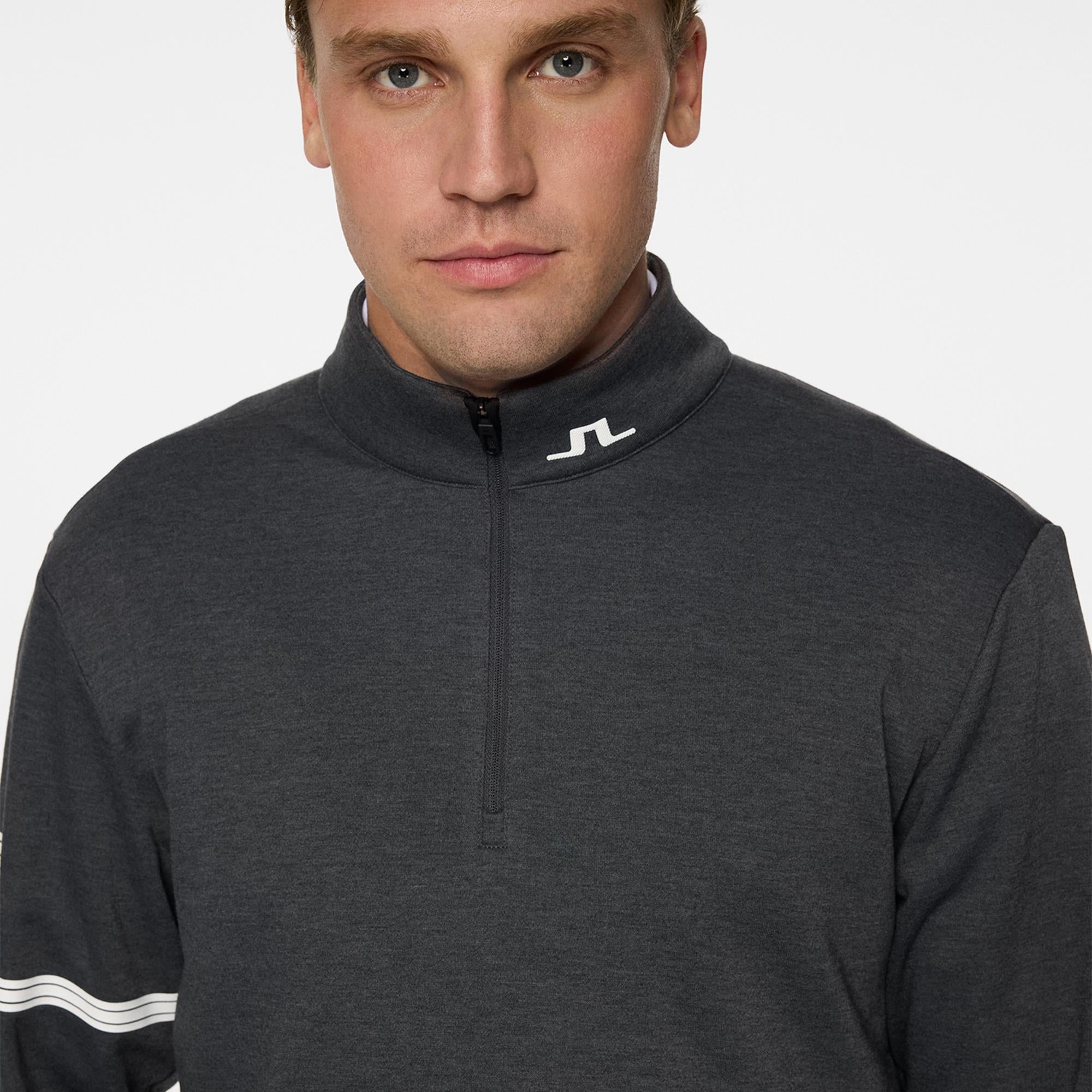 Model arms crossed showing sleeve logo – Heath Strike Golf Mid Layer Asphalt