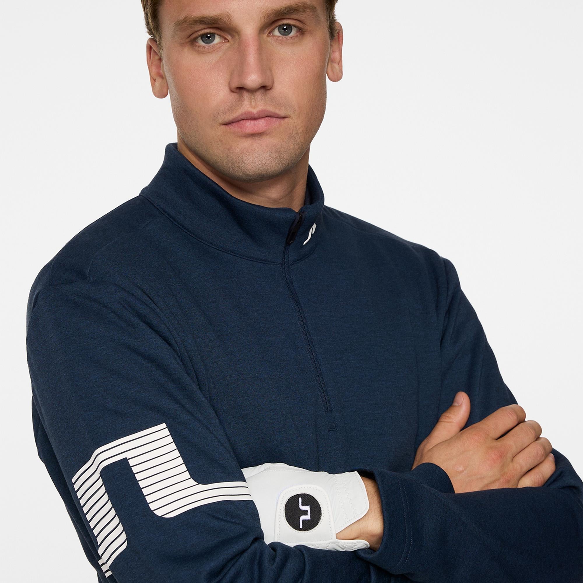Close-up of J.Lindeberg rubber Bridge logo on sleeve – Heath Strike Mid Laye