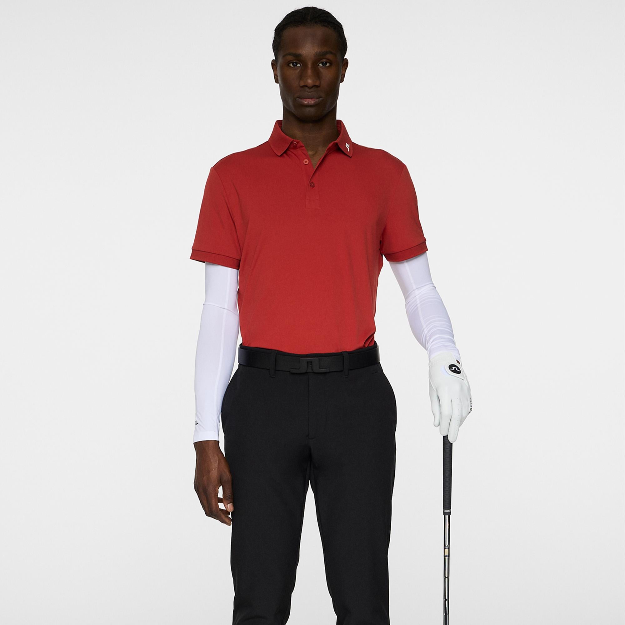 Model holding golf club in J.Lindeberg KV Polo – Bossa Nova
