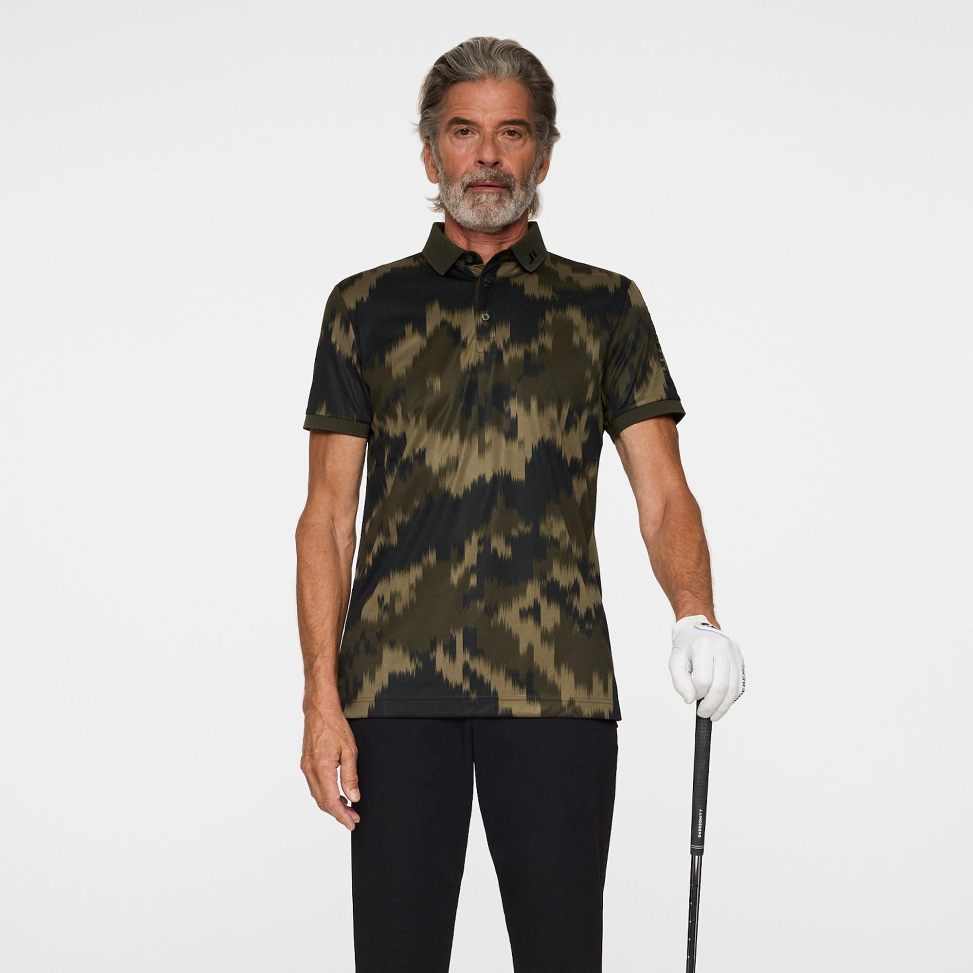 Model wearing J.Lindeberg men’s golf polo shirt holding golf club – Teepeg golf clothing