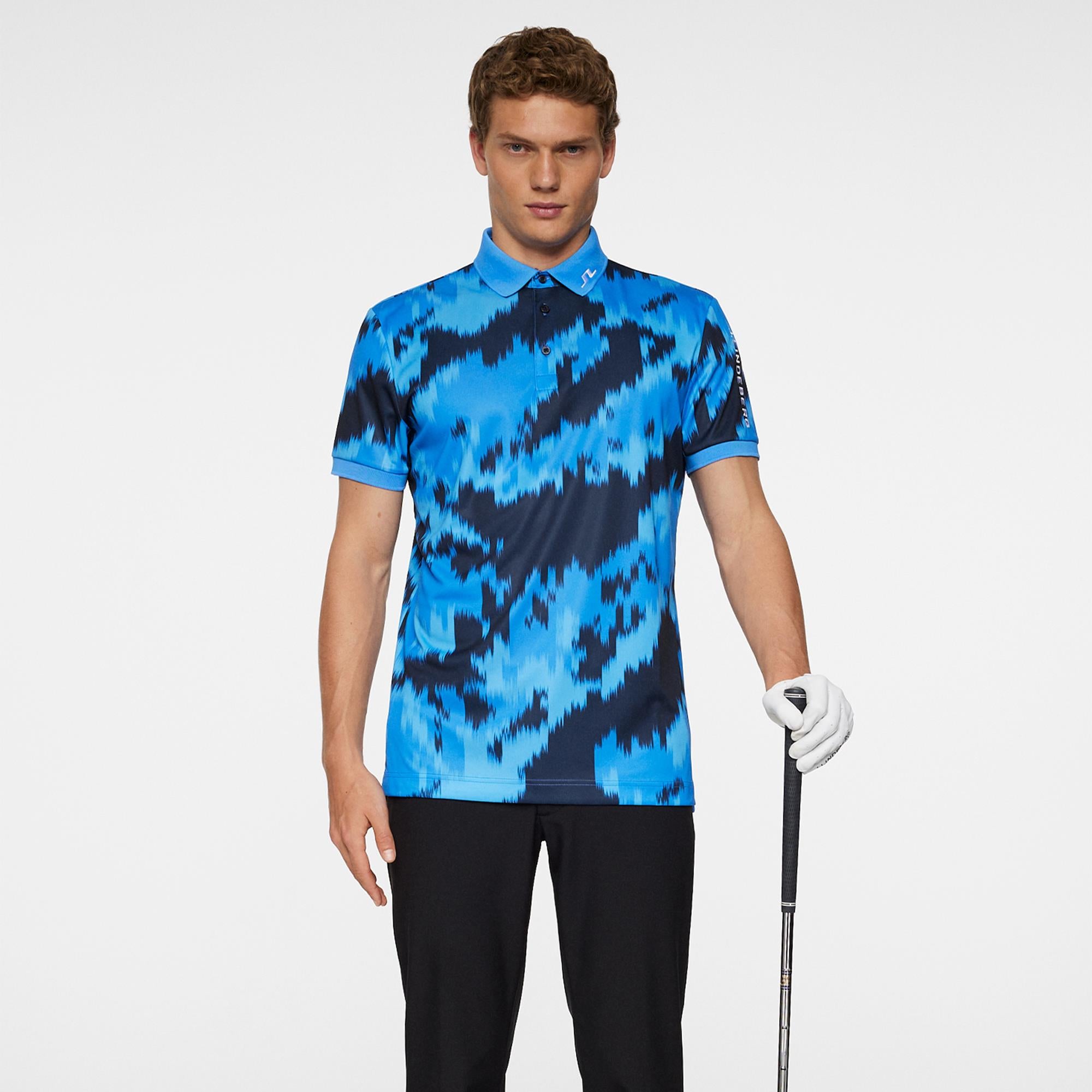 Model wearing J.Lindeberg men’s golf polo shirt holding golf club – Teepeg golf collection