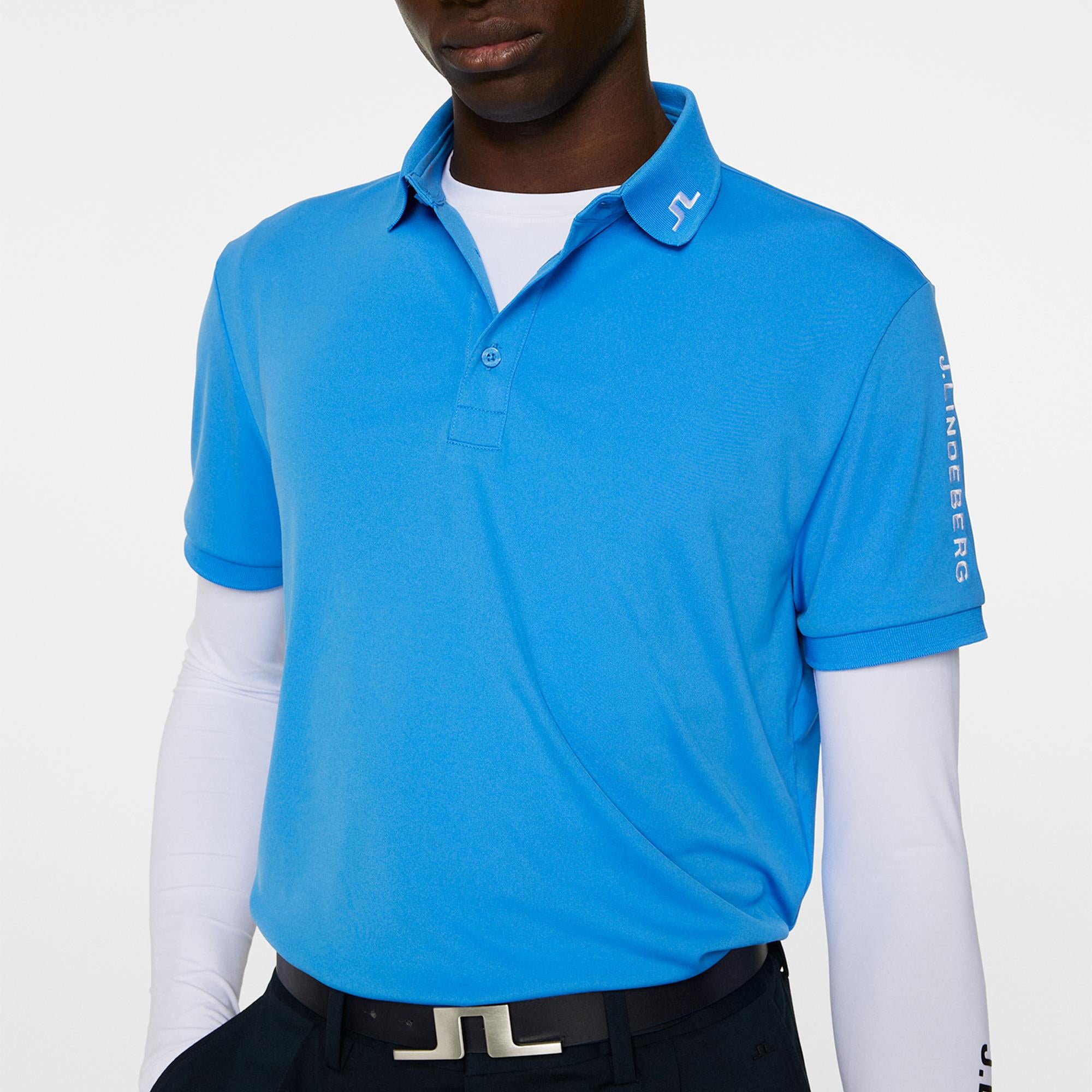 Angled shot of model in J.Lindeberg Sonic Blue Tour Tech Golf Polo