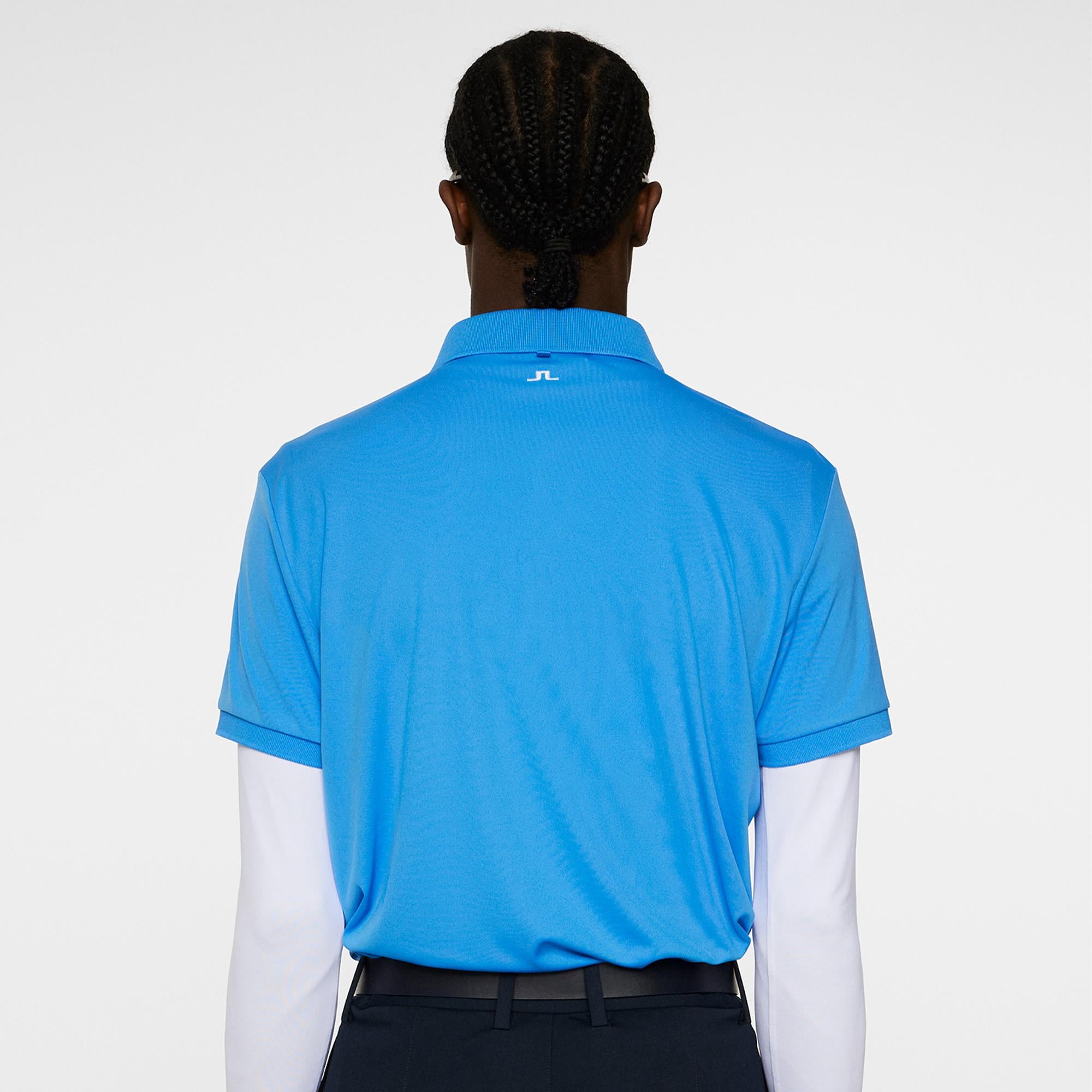 Back view of model wearing Sonic Blue J.Lindeberg Tour Tech Polo