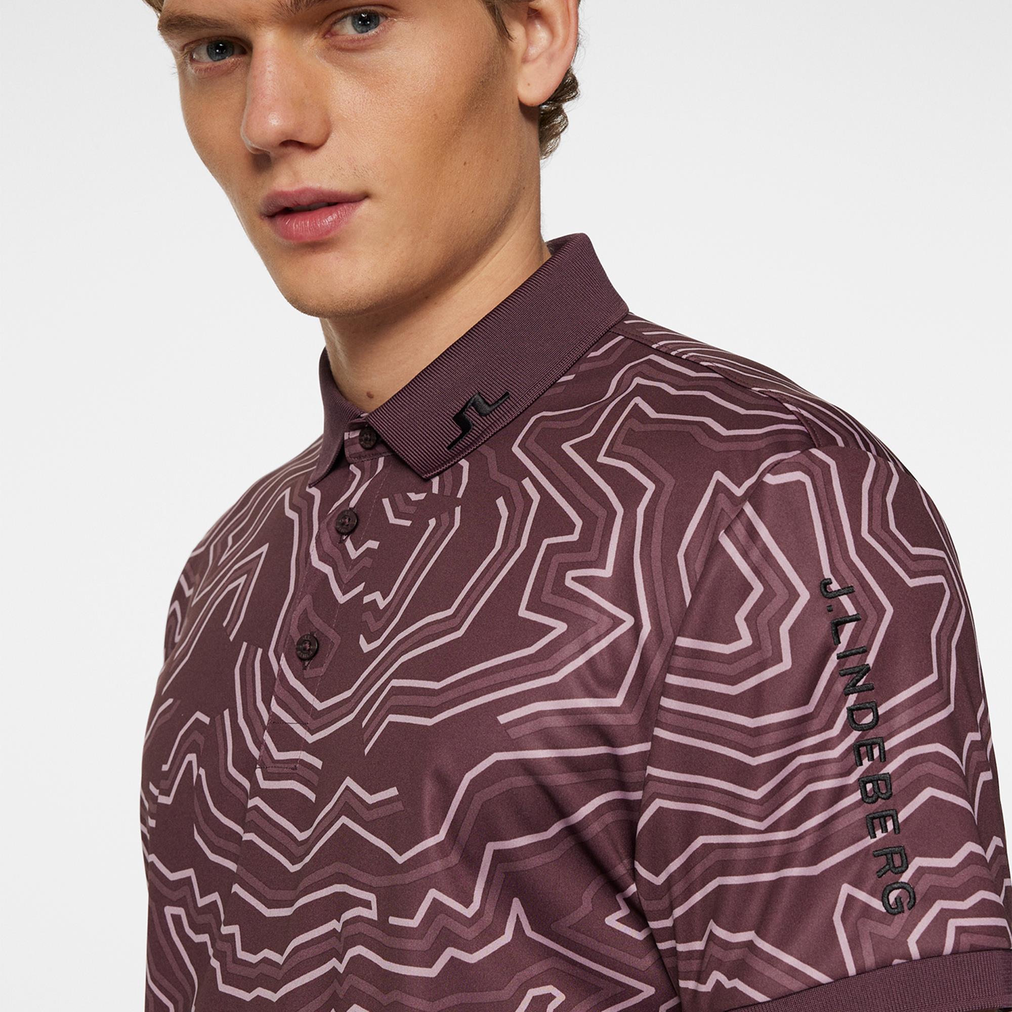 Close-up of model posing in J.Lindeberg men’s golf polo shirt Topo Huckleberry – modern golf style